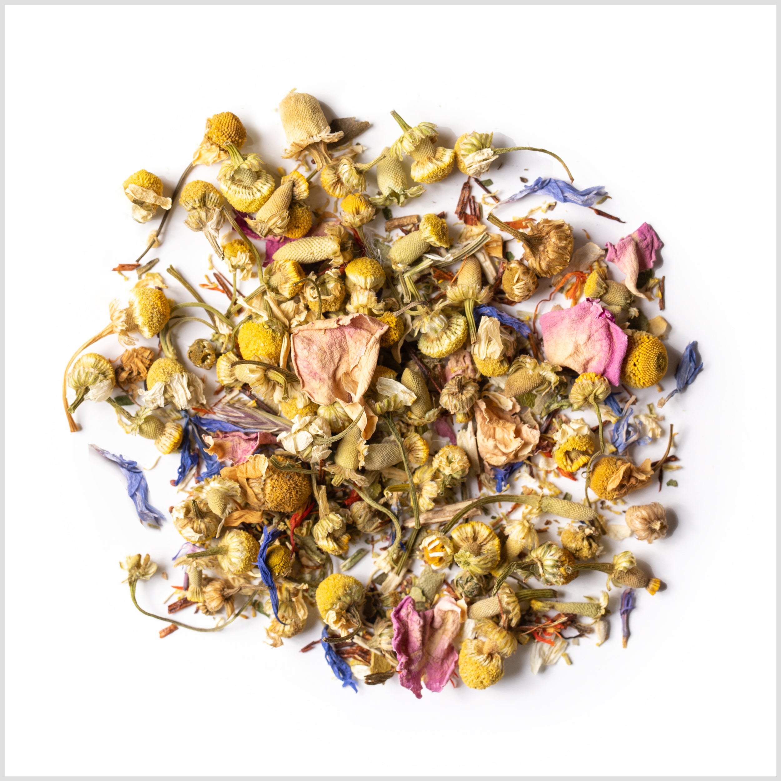 Pile of loose leaf Apple Brandy Meadow herbal infusion to show detail of full leaf chamomile buds, rose petals and cyani flowers.