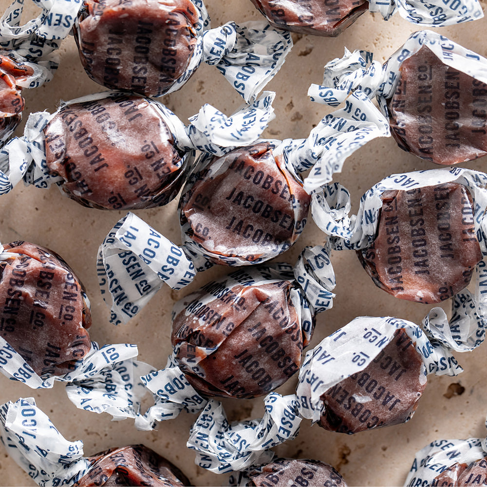 Close up on Jacobsen Co. Salty Chocolate Caramels to show detail of caramel morsels wrapped in Jacobsen Co. branded wrappers.