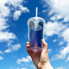 Clear cold cup with Blackberry Jasmine Iced Tea held up to the sky.