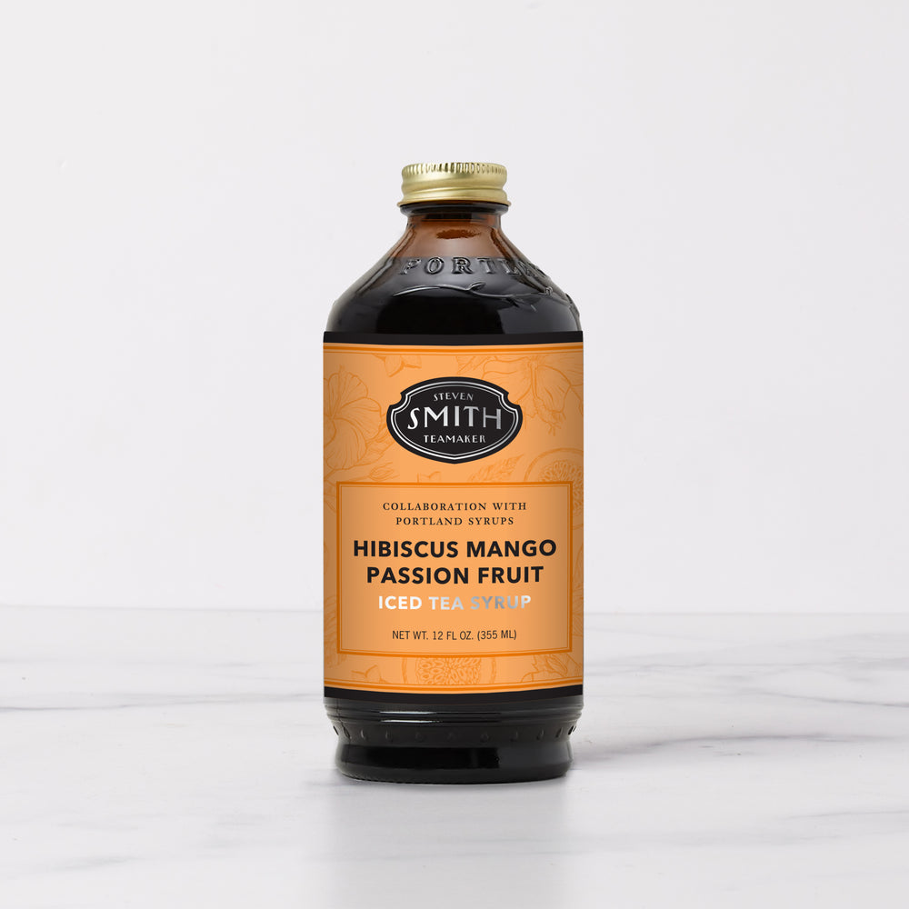 Bottle of Hibiscus Mango Passion Fruit Syrup with an orange label.