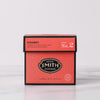 Deep pink box of Kissmet herbal infusion against a marble backdrop.